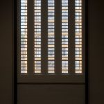 Interior view of plantation shutters allowing light to filter into a room